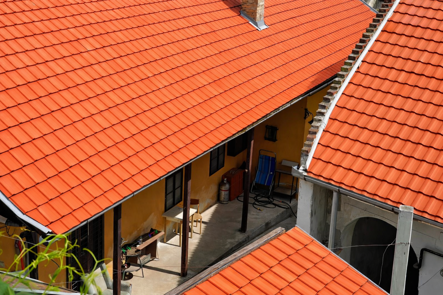 Red tiled rooftops overlook a yellow building with a small courtyard.