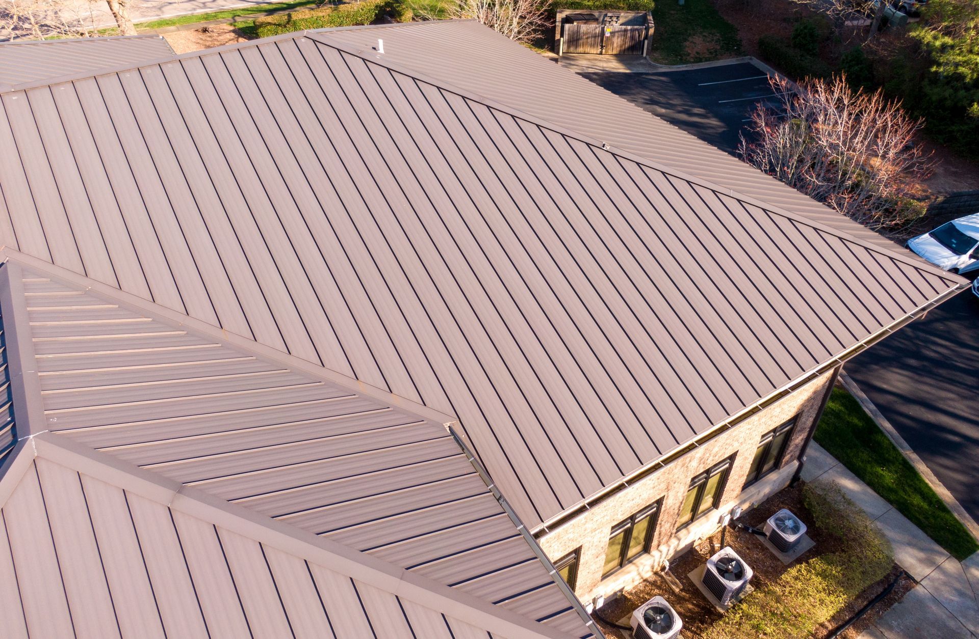 Brown metal roof of a building with visible seams, angled view.