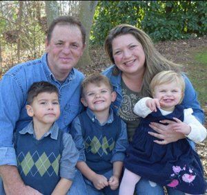 A family posing for a picture with two boys and a girl