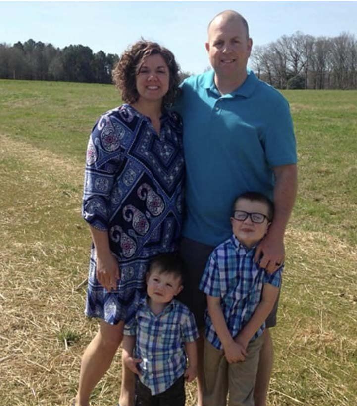 A family poses for a picture in a grassy field