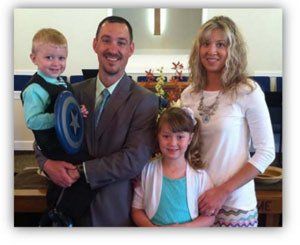 A family posing for a picture with a man holding a captain america frisbee