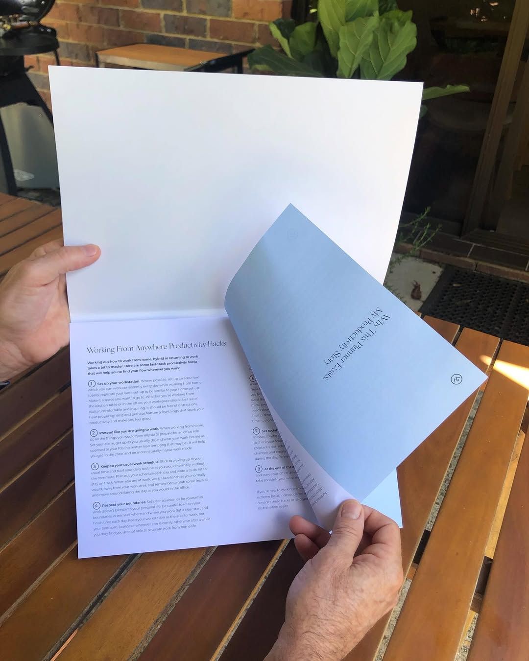 Person Holding Open a Booklet with Text on A Wooden Table Outdoors — Digi Print Pro in Ballina, NSW