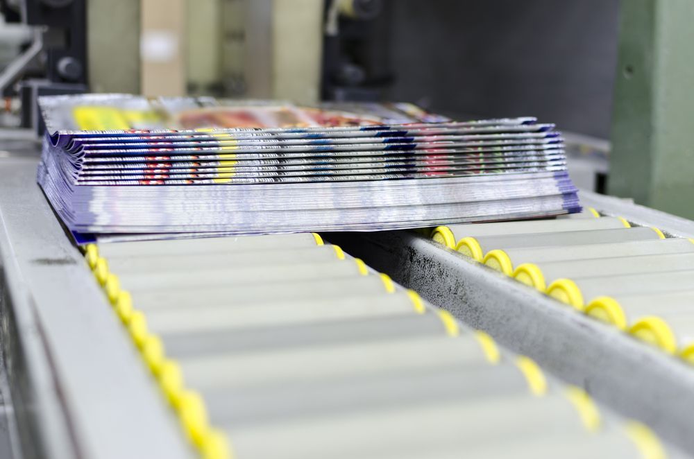 Magazines Stacked on A Conveyor Belt in A Factory, Ready for Distribution — Digi Print Pro in Lismore, NSW