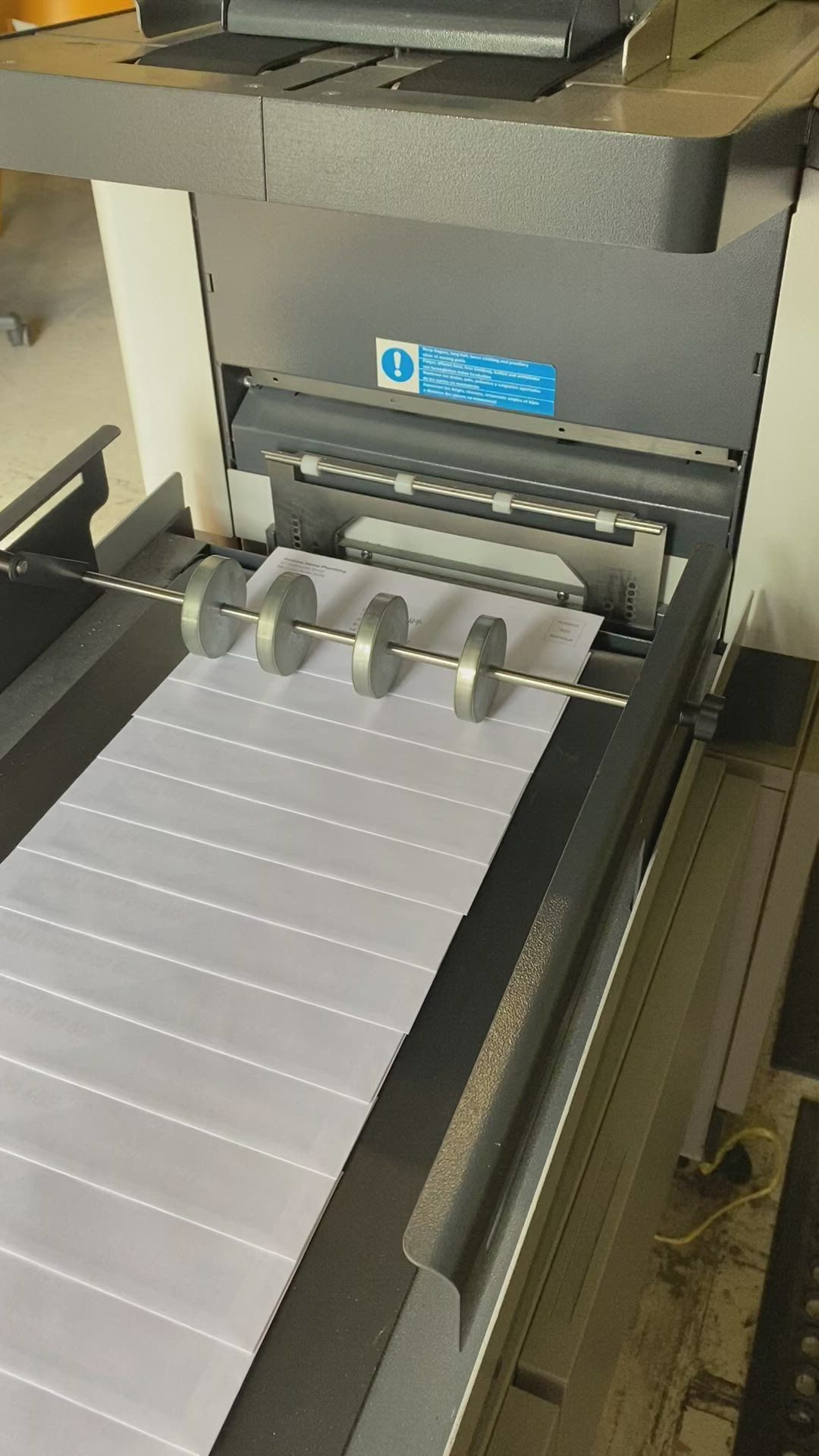 Machine Folding a Long Sheet of Gray Paper — Digi Print Pro in Bangalow, NSW