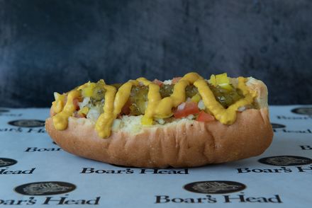A hot dog with mustard and pickles on a bun