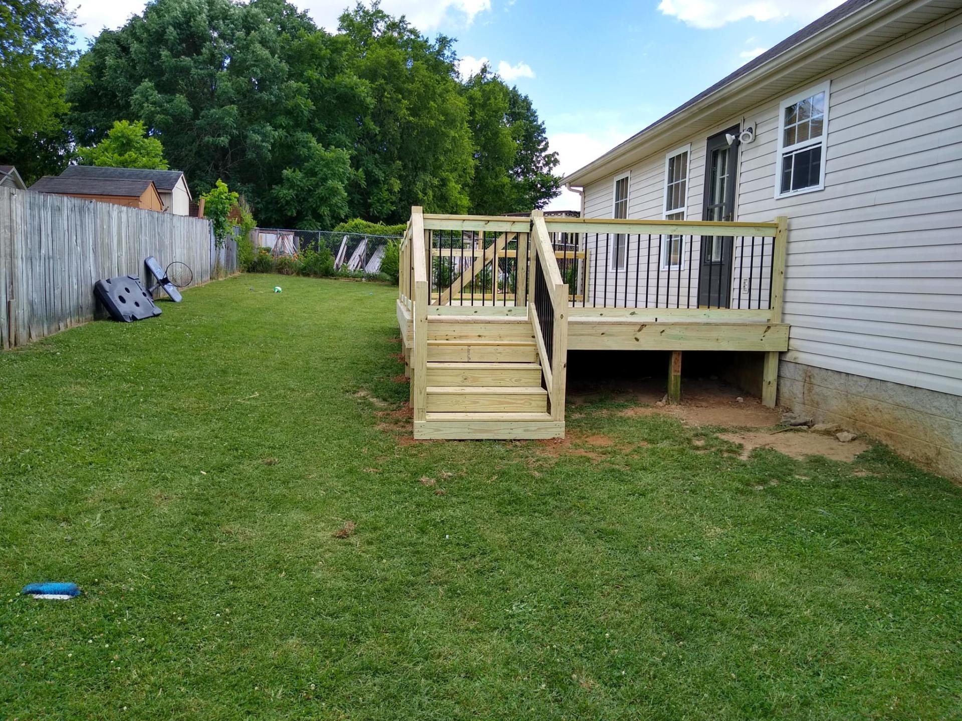 A wooden deck with stairs is in the backyard of a house. Clarksville, TN