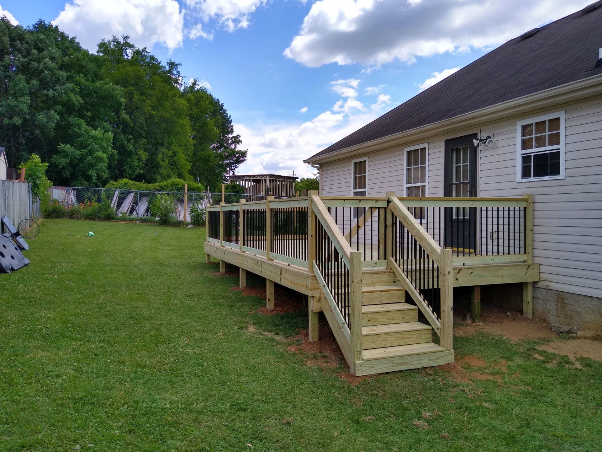 A wooden deck with stairs is in the backyard of a house. Clarksville, TN