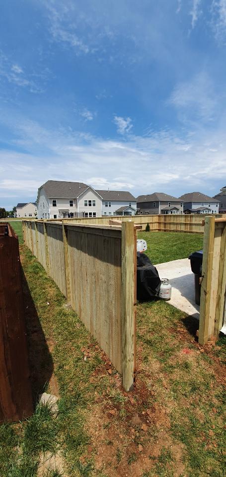 A wooden fence in a backyard with houses in the background. Clarksville, TN