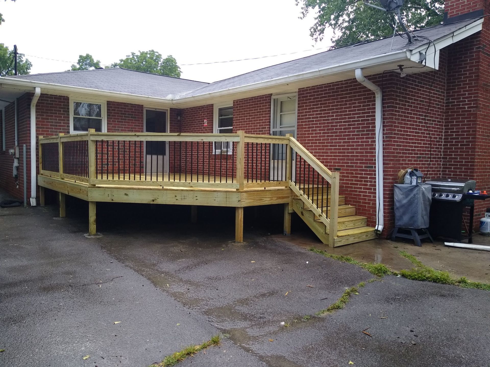 A brick house with a wooden deck and stairs in front of it. Clarksville, TN