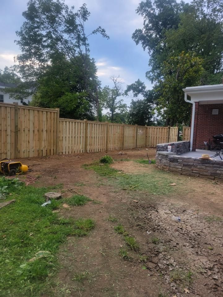 There is a wooden fence in the backyard of a house.