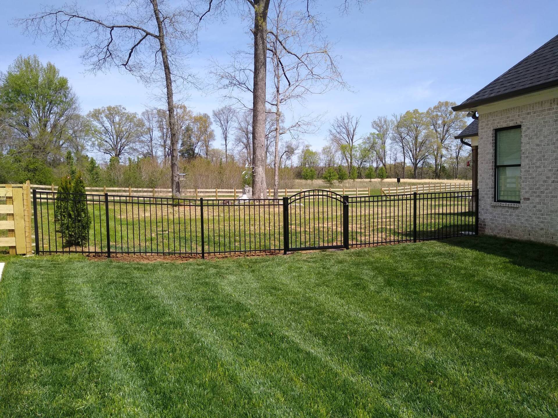 A house with a fence and a gate in the backyard.