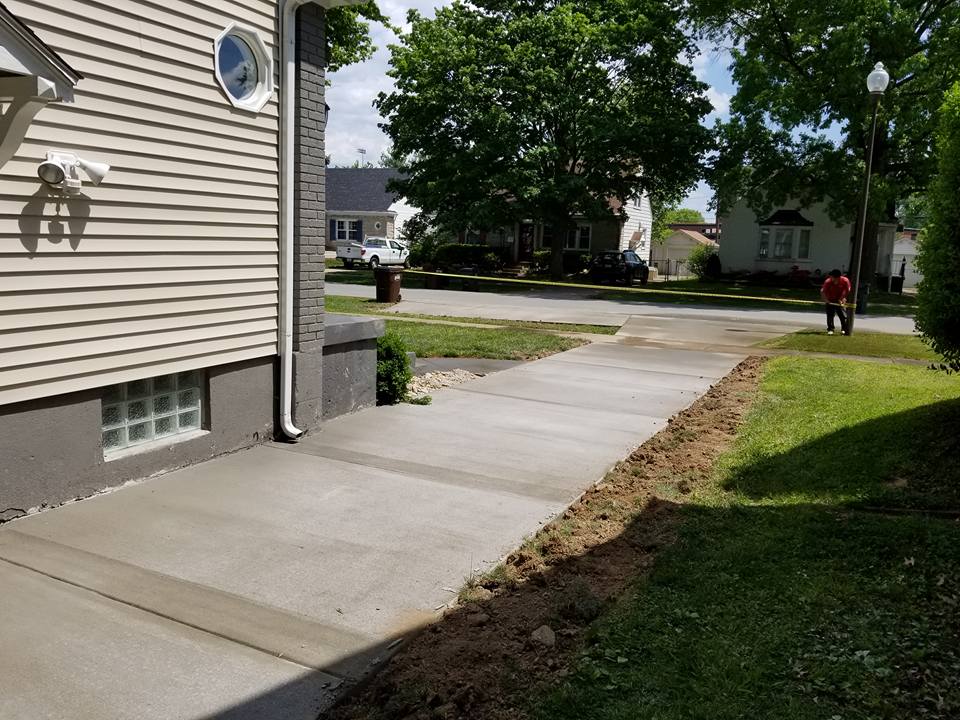 Pathway Constructors — Man Clipping Yellow Tape for the Newly Build Sidewalk in Louisville, KY