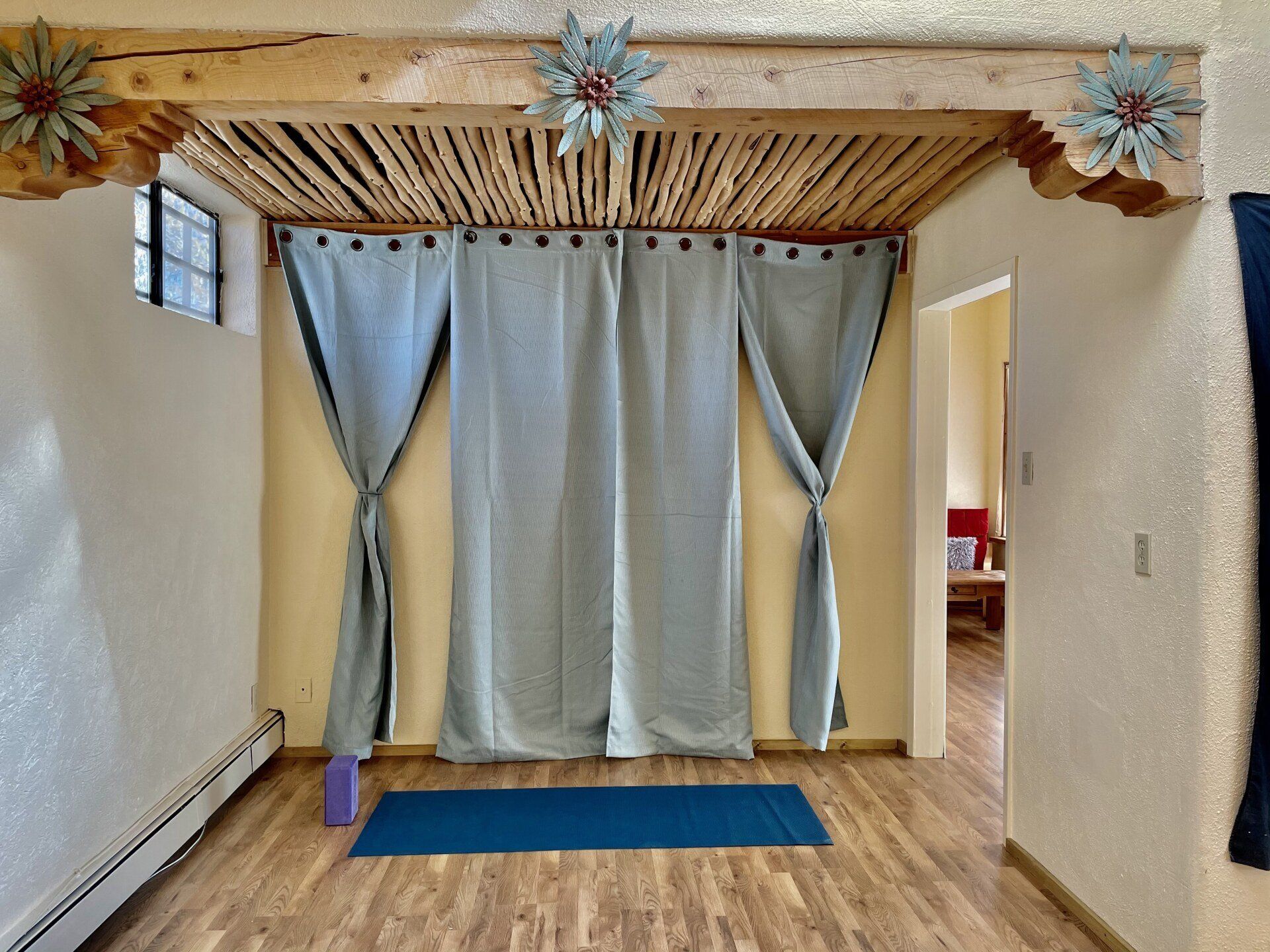 A room with a yoga mat and curtains on the wall