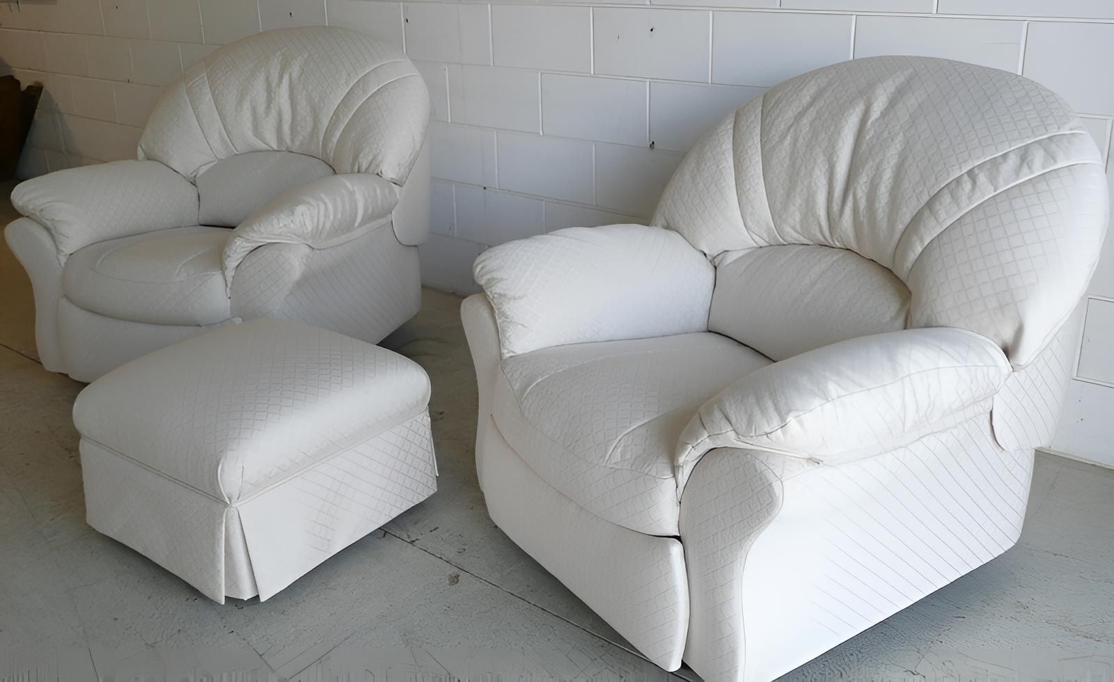 Two White Chairs And An Ottoman Are Sitting In Front Of A White Brick Wall — Stitch Master in Manunda, QLD