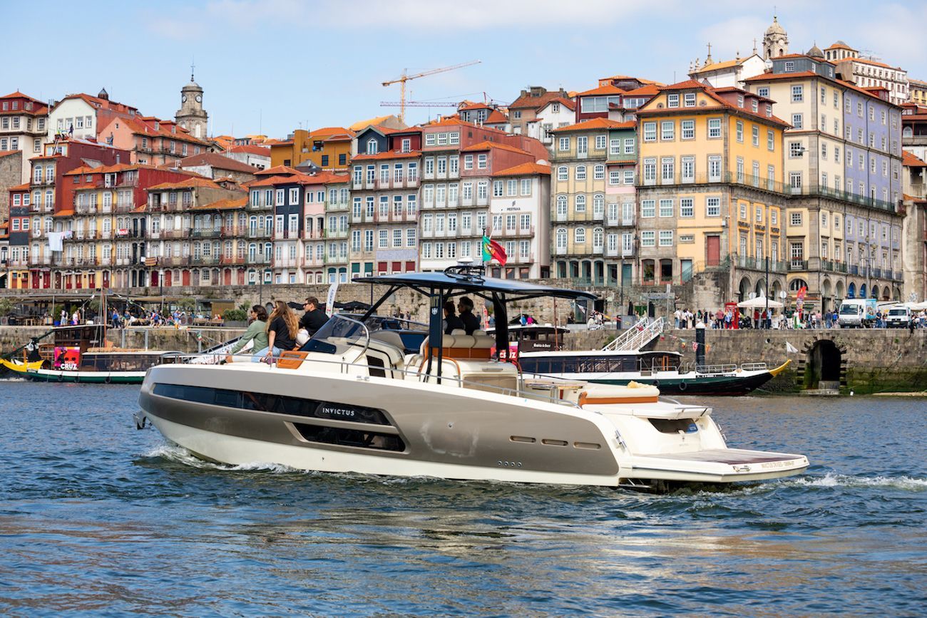 Um barco está flutuando sobre um corpo d'água em frente a uma cidade.