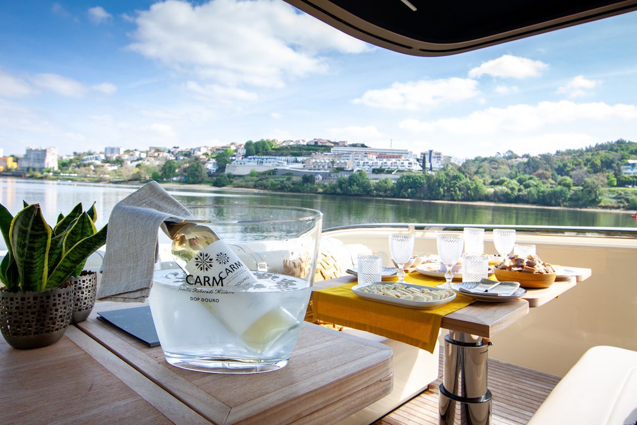 Uma mesa com uma garrafa de champanhe e vista para um lago.