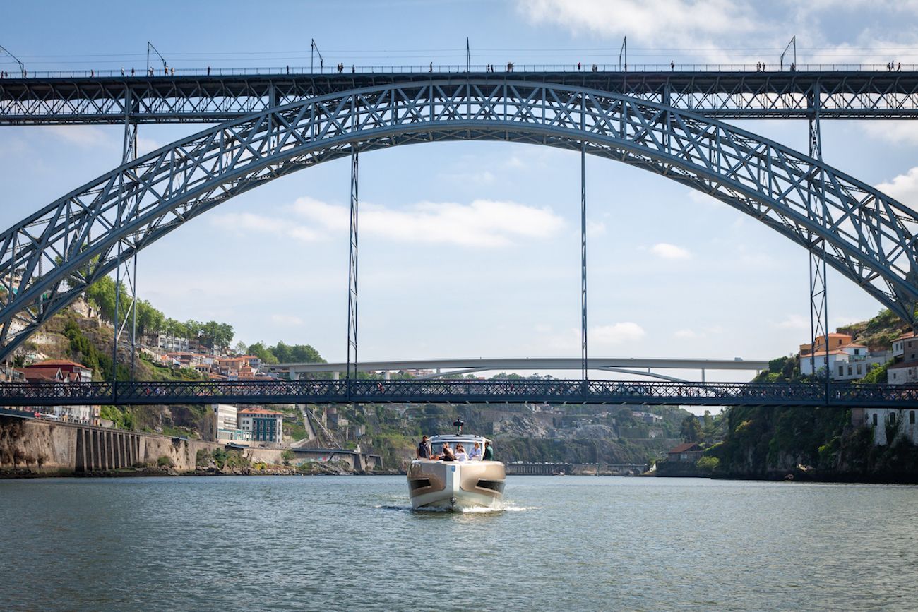 Um barco está passando por baixo de uma ponte sobre um corpo d'água