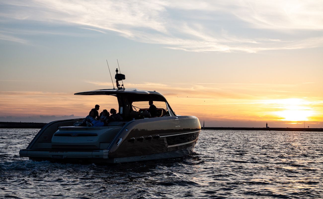 Um barco está flutuando sobre um corpo de água ao pôr do sol.