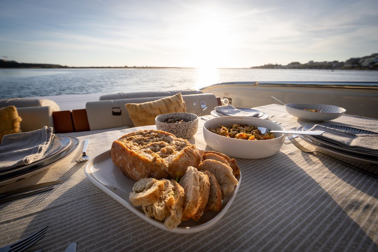 Há um prato de pão e uma tigela de comida na mesa.