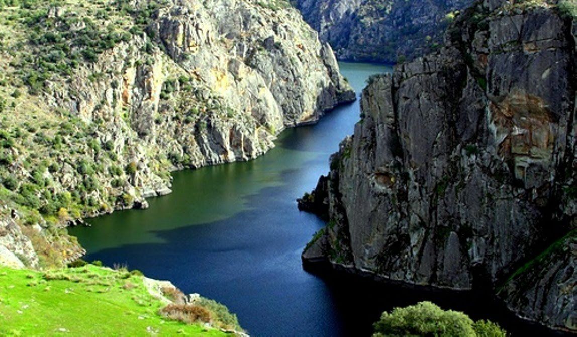 A river runs through a valley between two cliffs