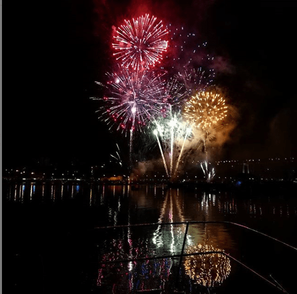 Fireworks are displayed over a body of water
