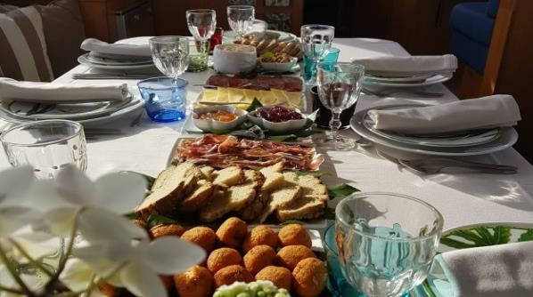 Uma mesa com pratos, copos e uma variedade de comidas.