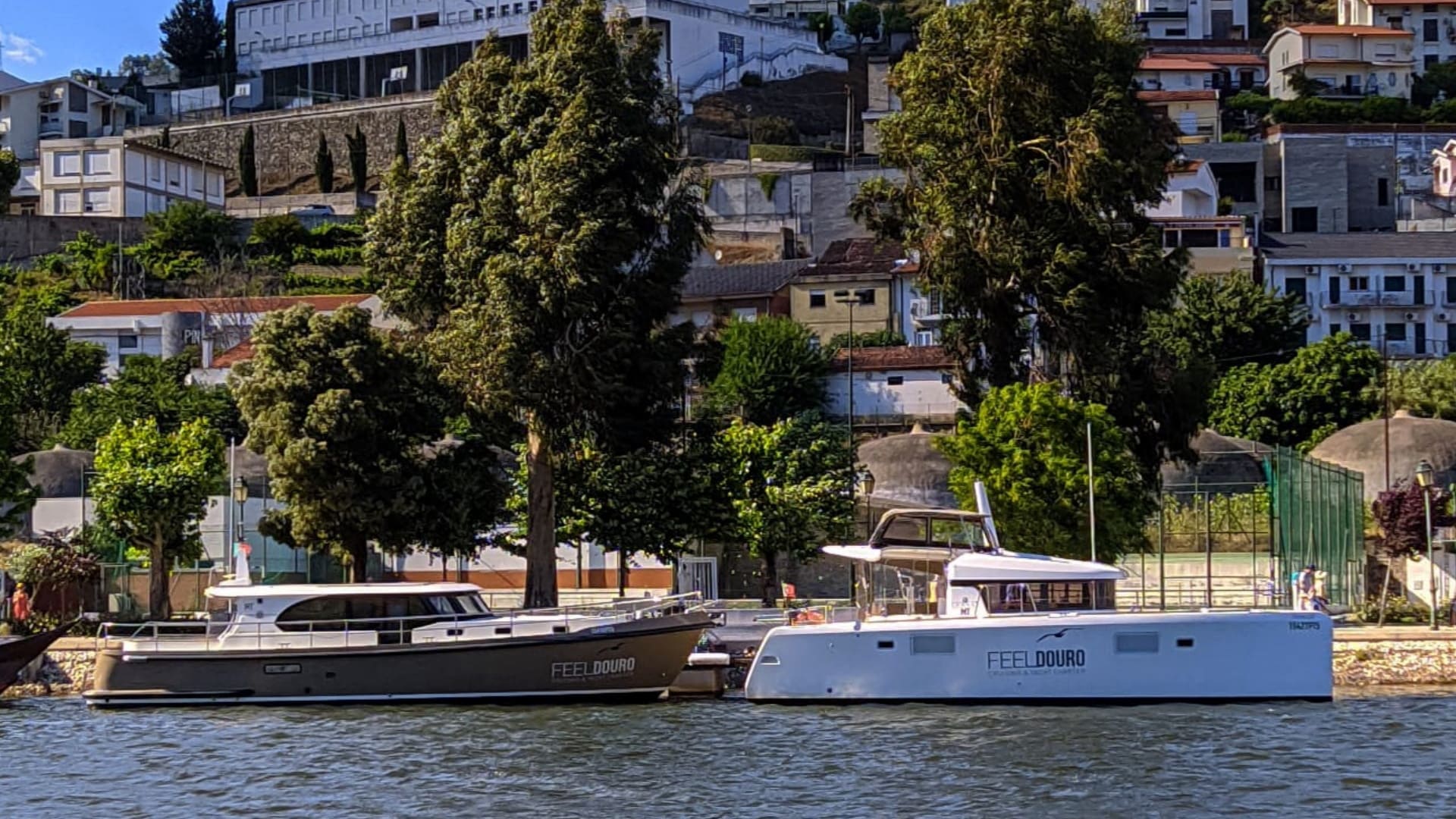 Two boats are docked next to each other on a body of water.