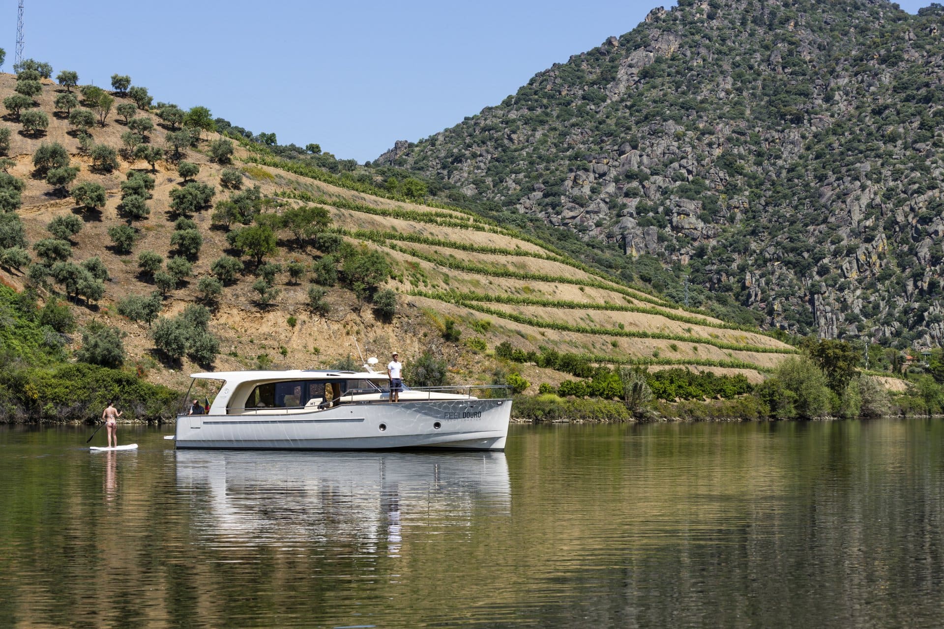 Um barco está flutuando em um lago com montanhas ao fundo