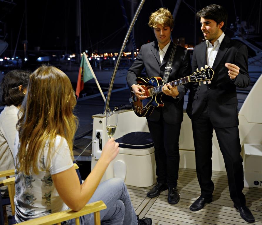 A man in a suit is playing a guitar in front of a group of people