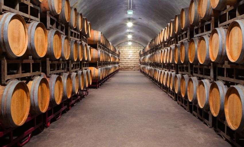 A wine cellar filled with lots of wooden barrels