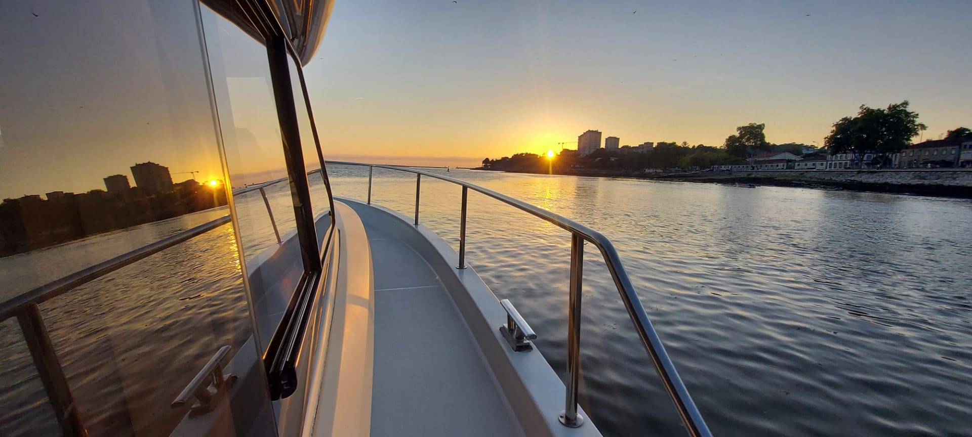A boat is floating on a body of water at sunset.