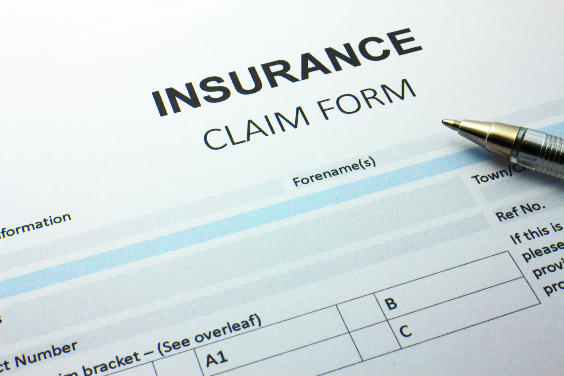 An insurance claim form with a pen on top of it