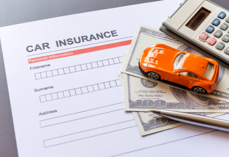 A toy car is sitting on top of a car insurance form.