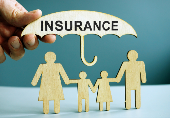 A person is holding a wooden umbrella with the word insurance on it.