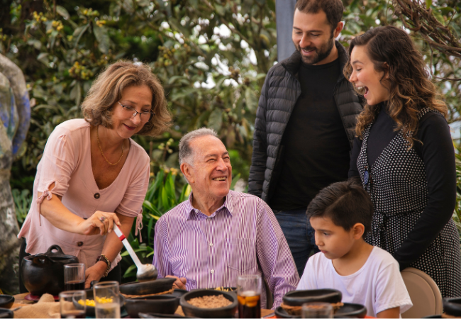 A family is sitting at a table eating food.