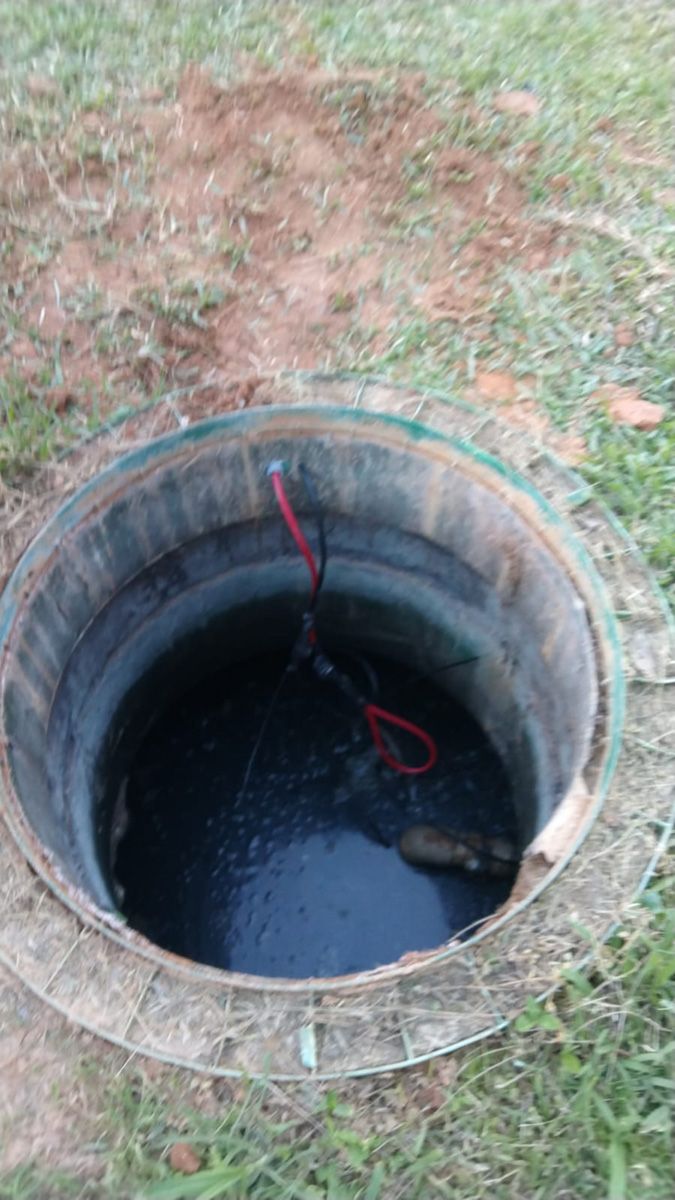 A manhole cover with a hole in the middle of it filled with water.