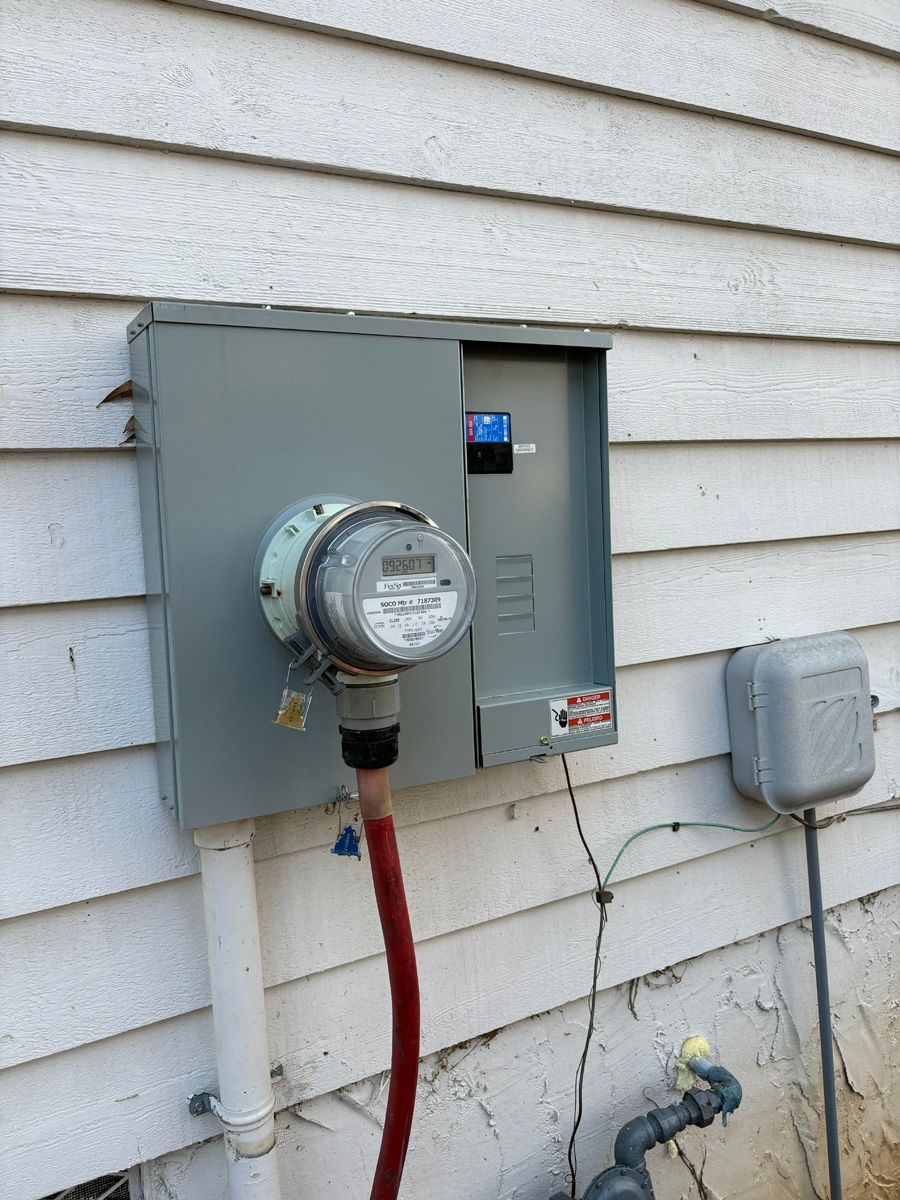 A meter is attached to the side of a house.