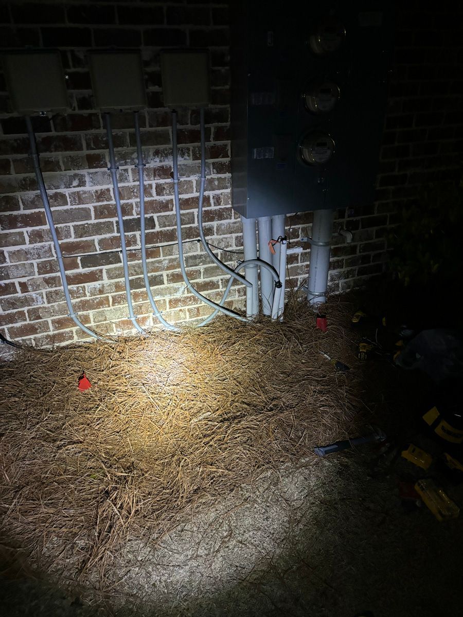 A flashlight is shining on a brick wall at night.