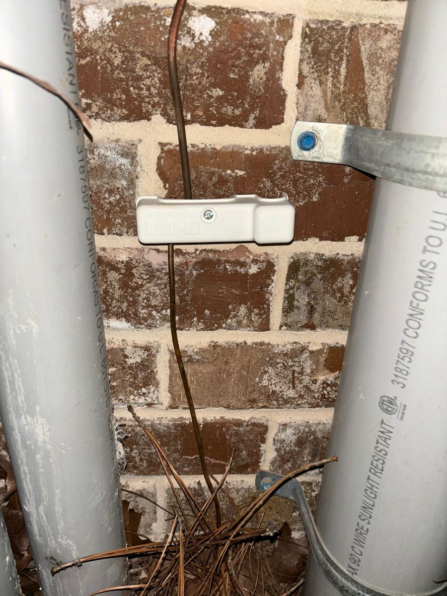 A brick wall with a bunch of pipes attached to it