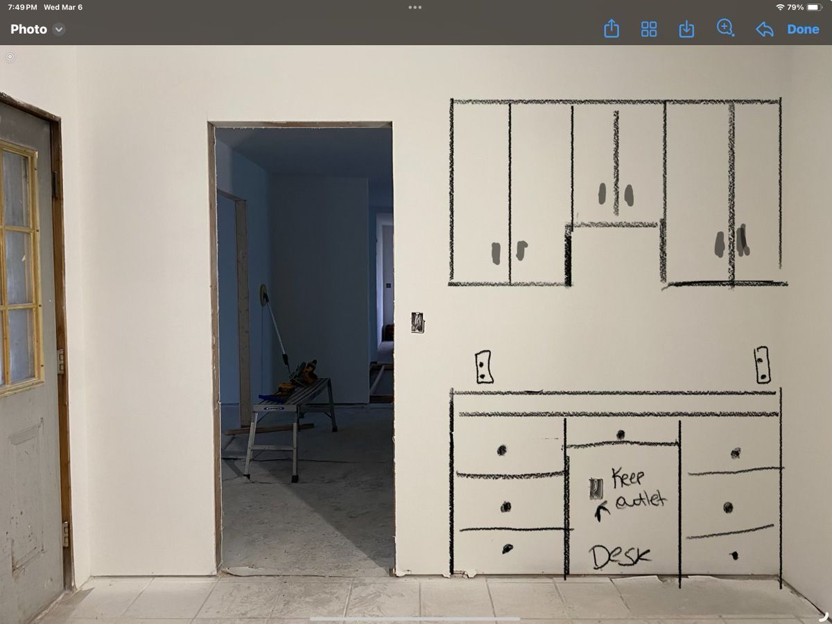 A drawing of a kitchen with cabinets drawn on the wall