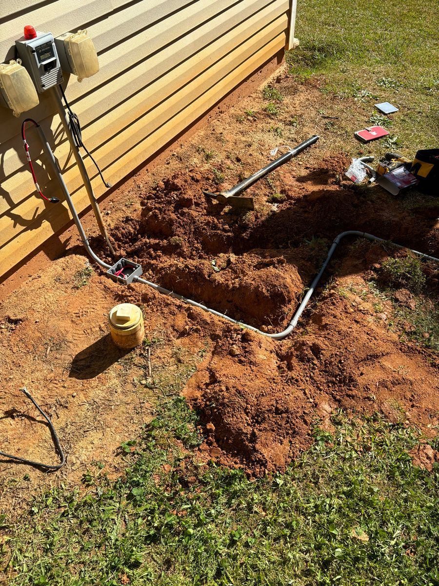 A person is digging a hole in the ground next to a house.