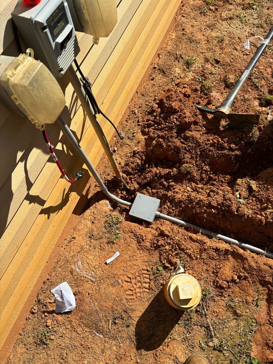 A person is digging a hole in the dirt next to a house.