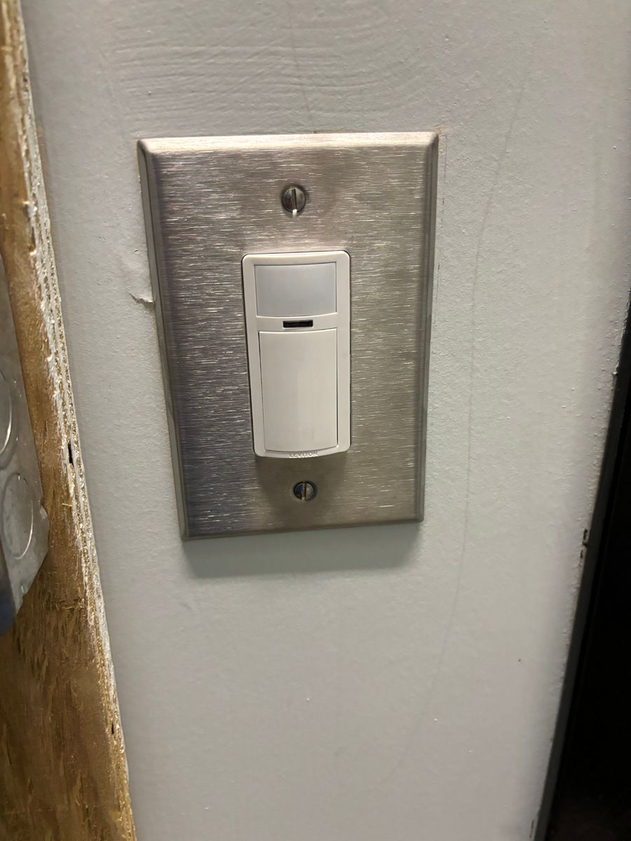 A light switch is mounted on a white wall.