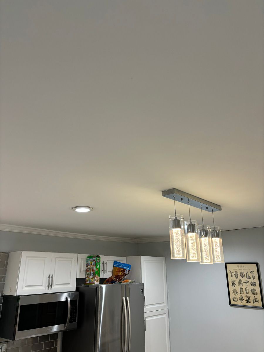 A kitchen with a refrigerator , microwave , and ceiling light.