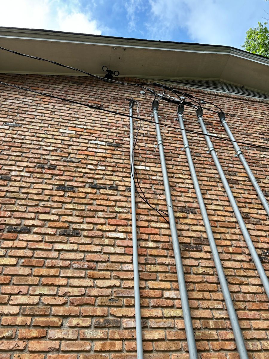 A brick wall with a bunch of pipes hanging off of it.