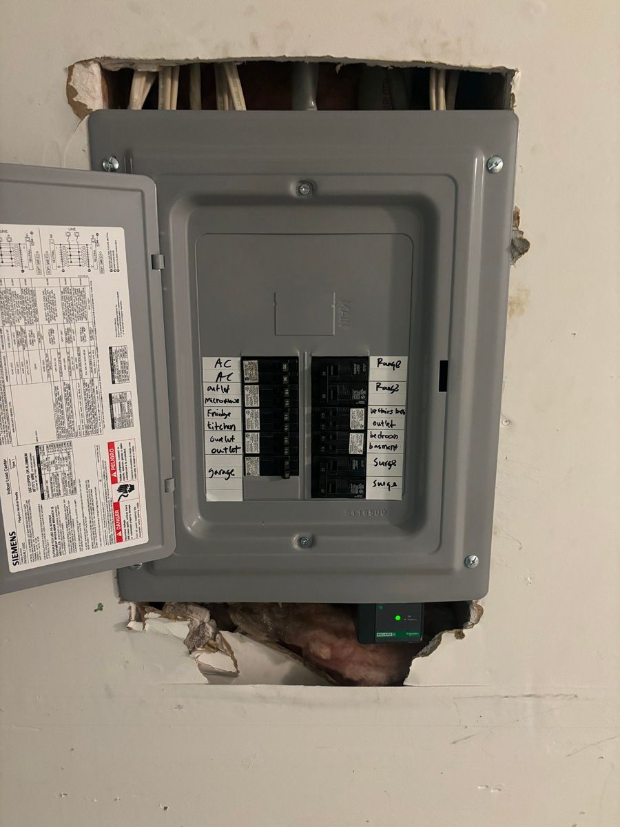 A electrical box is sitting in a hole in the wall.