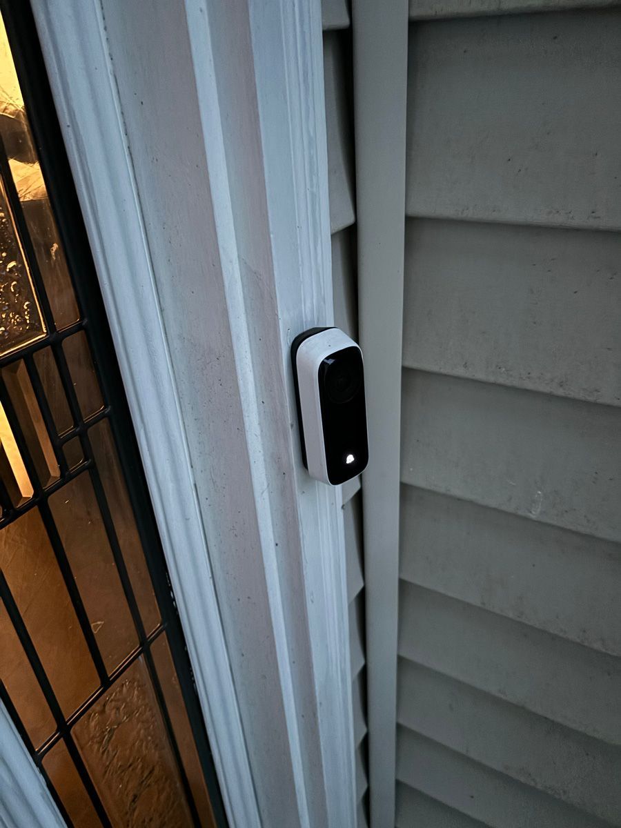 A doorbell is attached to the side of a house.