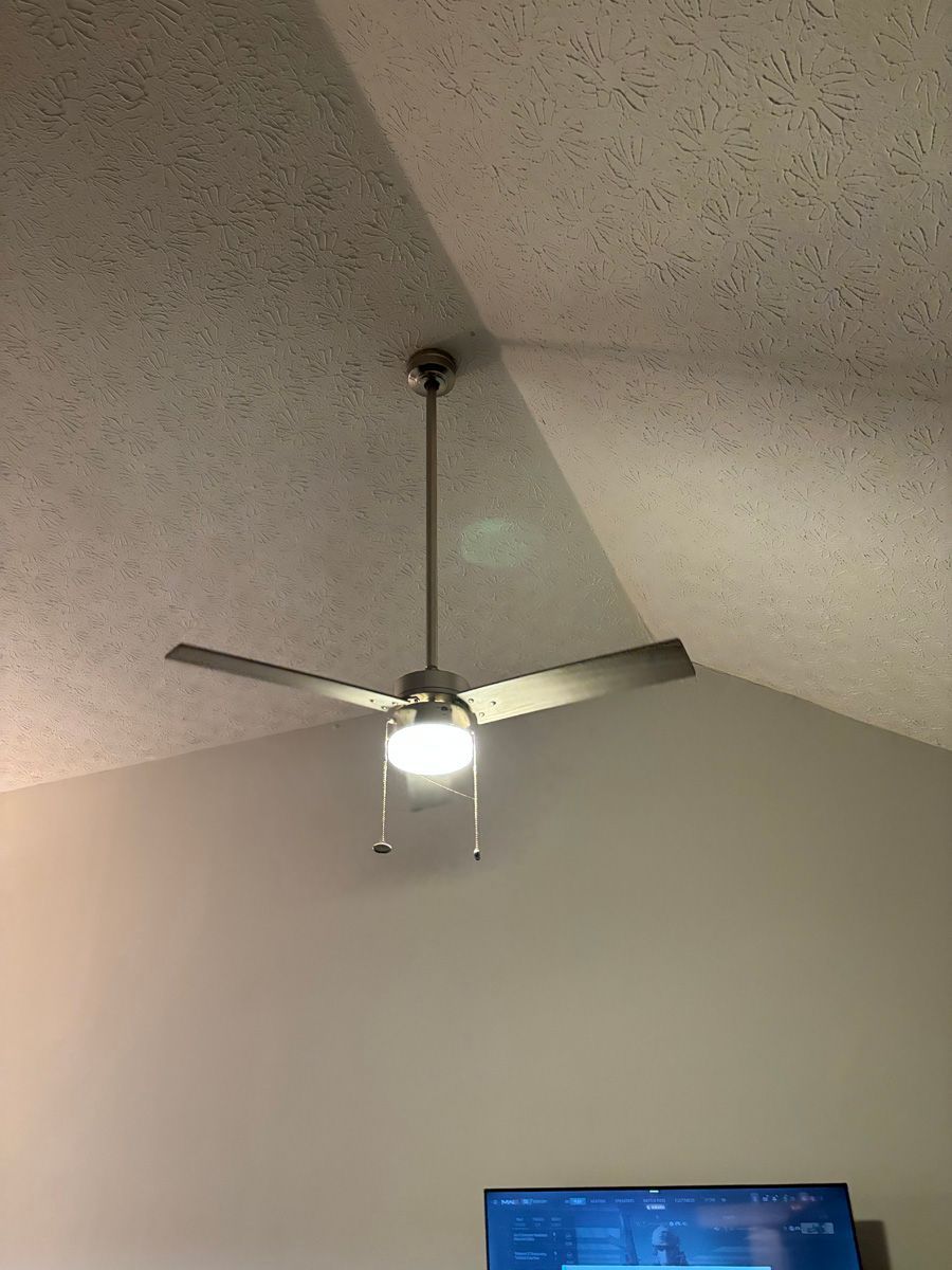 A ceiling fan is hanging from the ceiling in a living room.