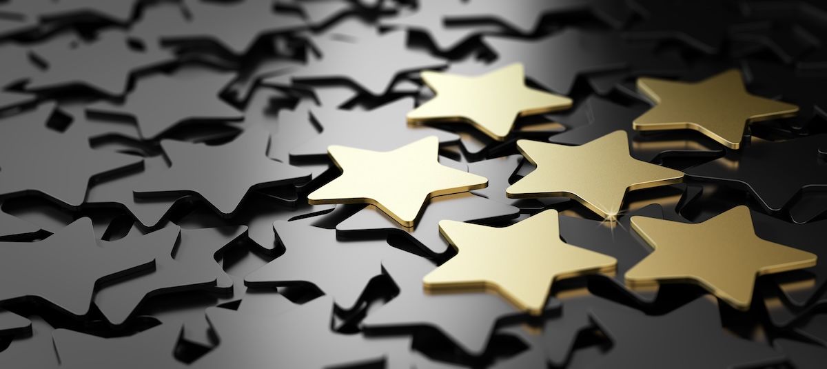 A group of gold stars sitting on top of each other on a black background.