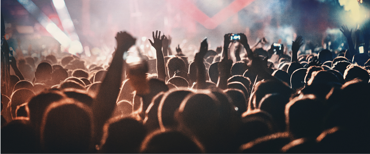 A crowd of people are taking pictures of a concert with their cell phones.